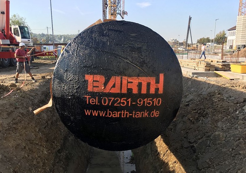 ein 100.000 l Regenwasserbeh&auml;lter der Firma Tank ud Apparate Barth GmbH wird von einem Bauarbeiter in die richtige Position zum Ablassen in die Baugrube gebracht